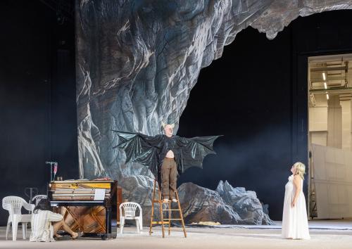 Sébastien Jacobs steht auf einer Leiter neben einem Klavier. Er trägt schwarze Fledermausflügel, die er ausbreitet. Bettina Stucky steht in einem weißen Kleid vor ihm und blickt zu ihm hoch. Im Hintergrund eine Felsenhöhle.
