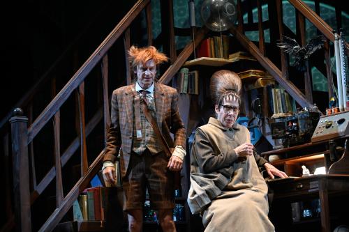 Jan-Peter Kampwirth steht neben Ute Hannig, die an einem Schreibtisch sitzt. Beide sind von Holzregalen mit Büchern umgeben.