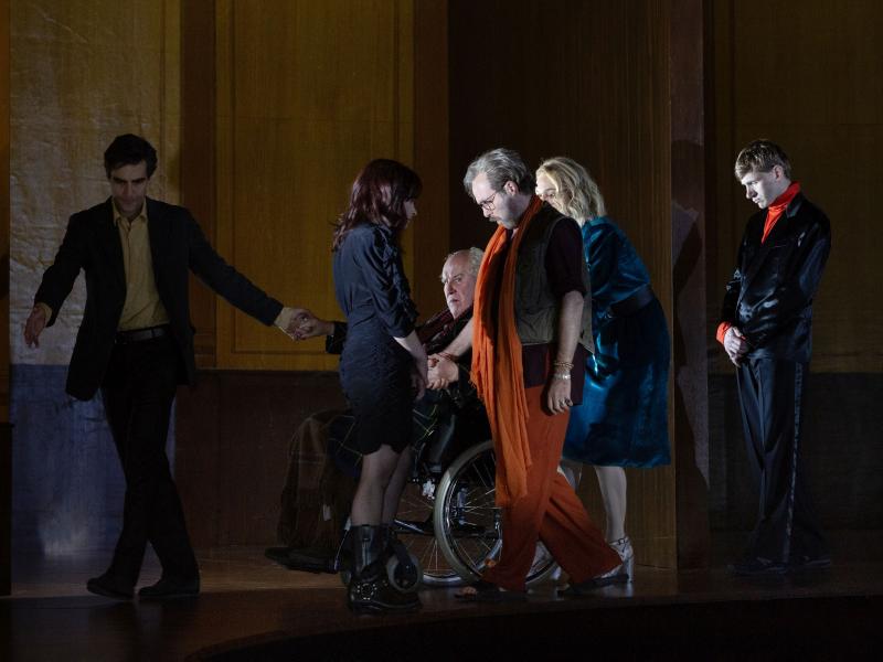 Pascal Houdus, Henni Jörissen, Samuel Weiss, Angelika Richter und Paul Behren stehen auf der Bühne. Josef Ostendorf sitzt in einem Rollstuhl und hält die Hand von Pascal Houdus. Alle sind dunkel angezogen und schau auf den Boden. 