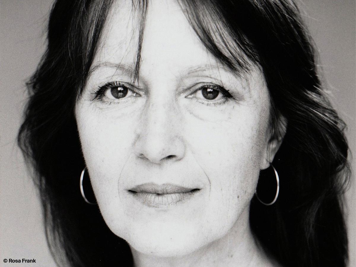 Schwarz-Weiß-Foto. Abgebildet ist die Schauspielerin Marlen Diekhoff. Sie trägt offene dunkle, lange Haare, dezente Ohrringe und schaut in die Kamera.