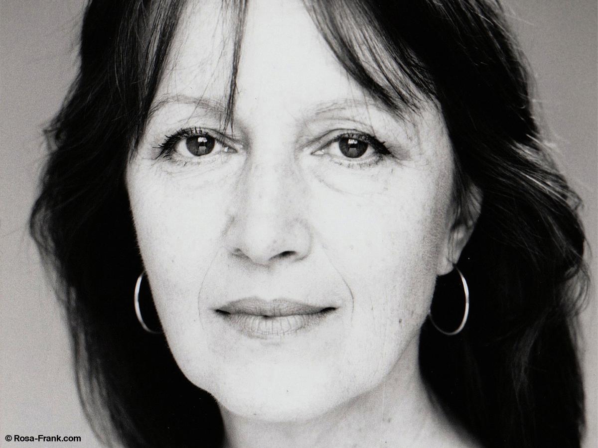 Schwarz-Weiß-Foto. Abgebildet ist die Schauspielerin Marlen Diekhoff. Sie trägt offene dunkle, lange Haare, dezente Ohrringe und schaut in die Kamera.